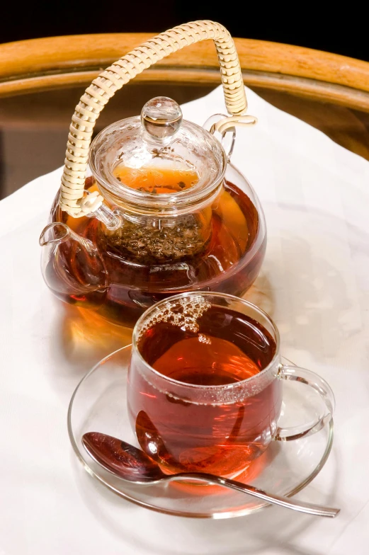 a tea pot sitting on top of a table next to a cup of tea, iced tea glass, thumbnail, crimson, soup