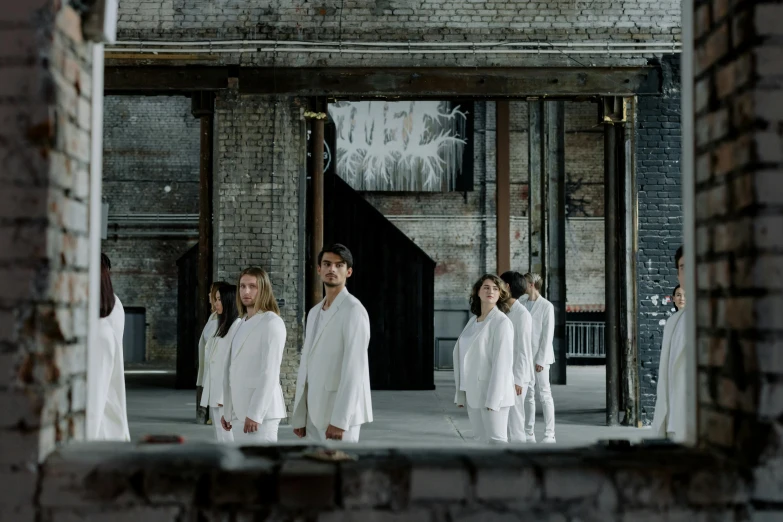 a group of people standing in front of a mirror, an album cover, inspired by Vanessa Beecroft, unsplash, gutai group, dressed in white robes, in a warehouse, actors, kalevala