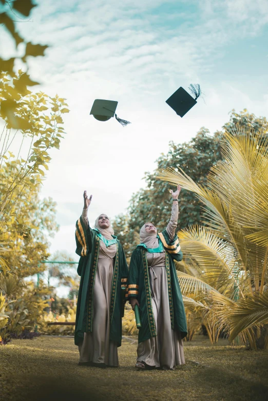 a couple of people standing on top of a lush green field, academic art, wearing an academic gown, 2019 trending photo, islamic, leaves in the air