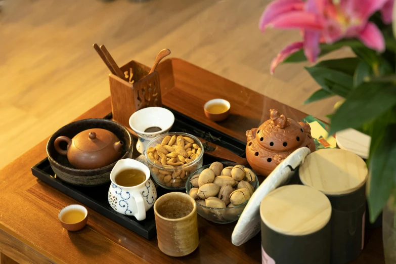 a close up of a tray of food on a table, a still life, inspired by Guo Chun, unsplash, mingei, square, brown, tea, hotel room