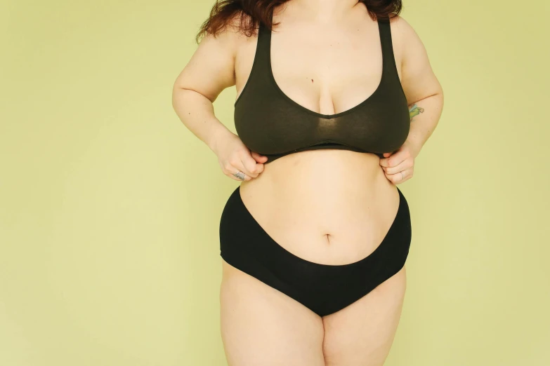 a woman in a black bikini posing for a picture, by Carey Morris, trending on pexels, renaissance, gradient from green to black, her belly is fat and round, nanae kawahara, bloated