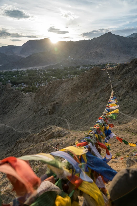 a long line of prayer flags hanging from the side of a mountain, inspired by Steve McCurry, trending on unsplash, sunset in the desert, view from slightly above, high-quality photo, india