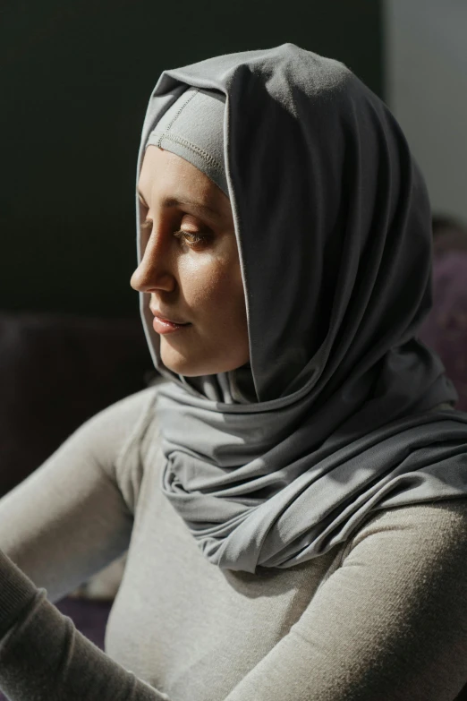 a woman in a hijab using a cell phone, a character portrait, pexels contest winner, sitting on couch, contemplative, portrait of head and body, detailled light