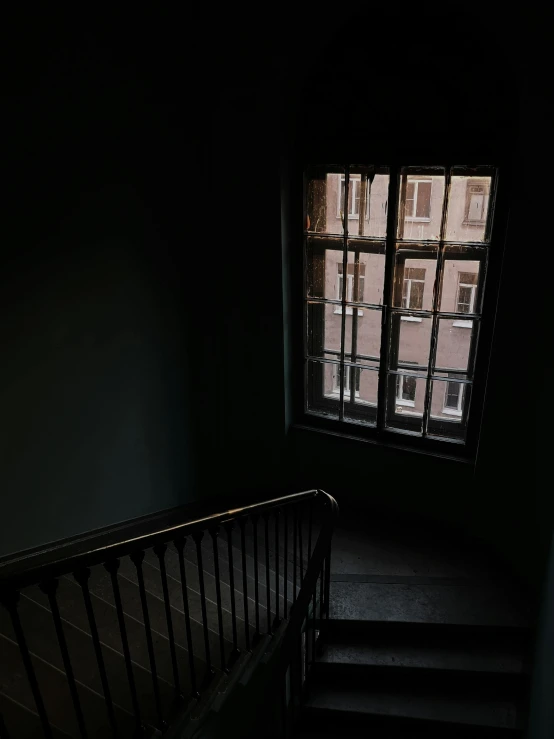 a staircase leading up to a window in a dark room, dark academia aesthetics, window ( city ), low quality photo, dark. no text