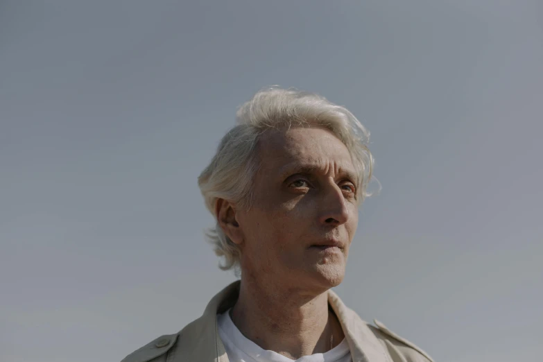 a close up of a person wearing a jacket, an album cover, inspired by roger deakins, pexels contest winner, photorealism, medium length slick white hair, giorgio di chirico, androgynous person, looking to the sky