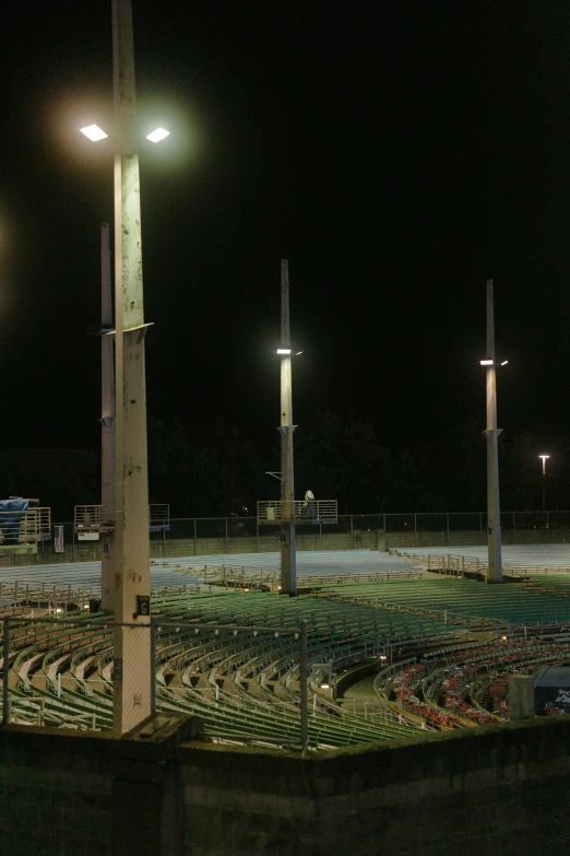 a baseball stadium is lit up at night, by Joe Stefanelli, happening, lamp posts, 2 0 0 mm wide shot, obelisks, outdoor fairgrounds