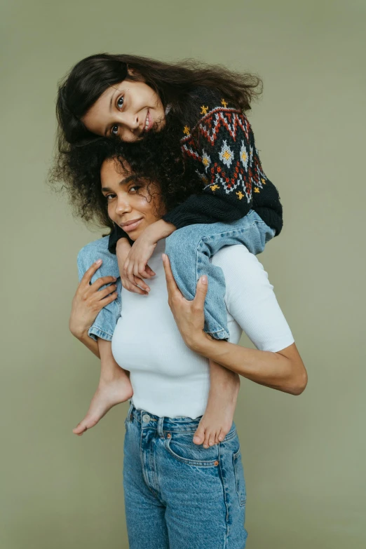 a woman carrying a child on her back, trending on pexels, studio portrait, wavy hair spread out, mixed styles, denim