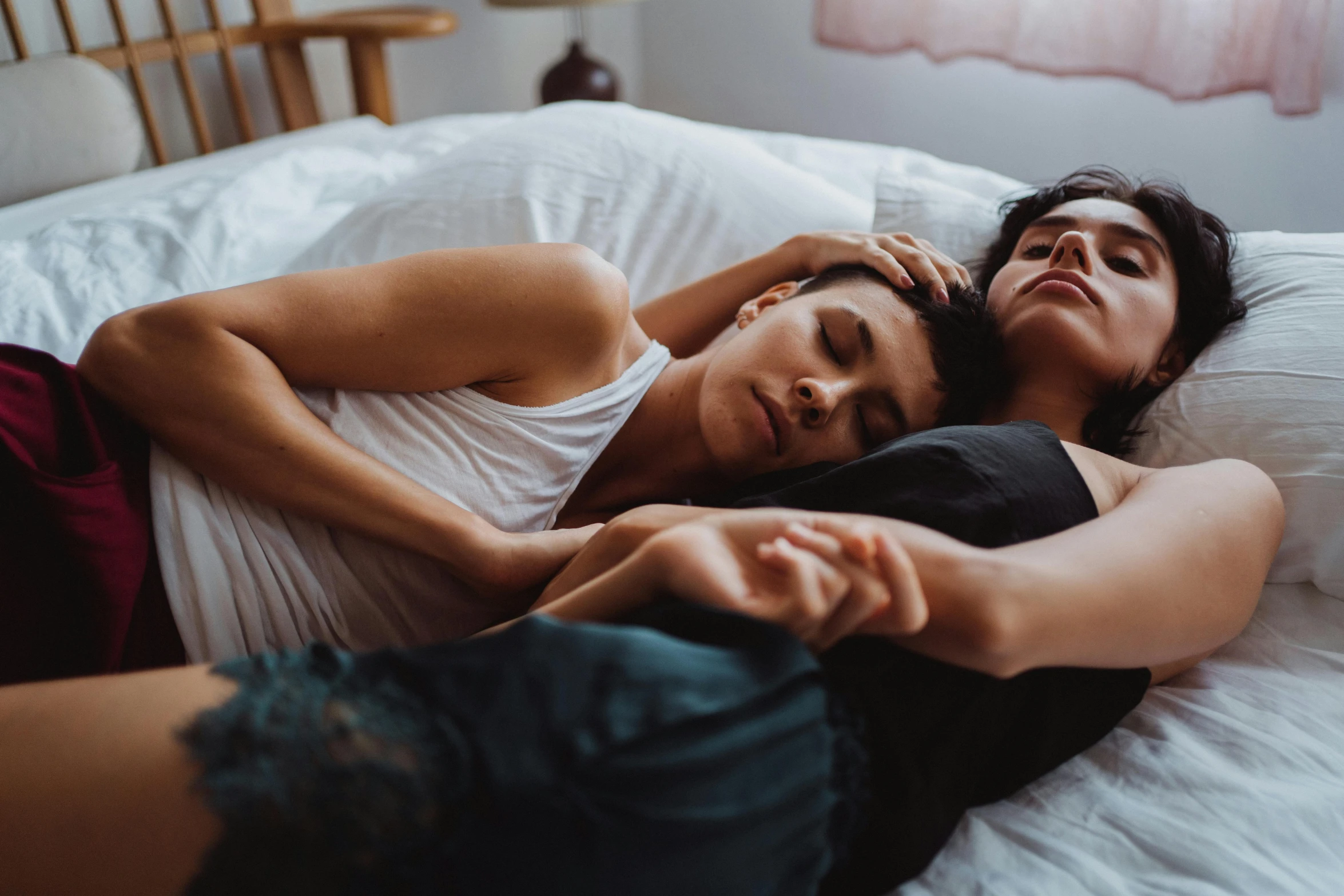 a couple of people laying on top of a bed, trending on pexels, lesbian embrace, 'i'm so tired, slightly realistic, woman holding another woman