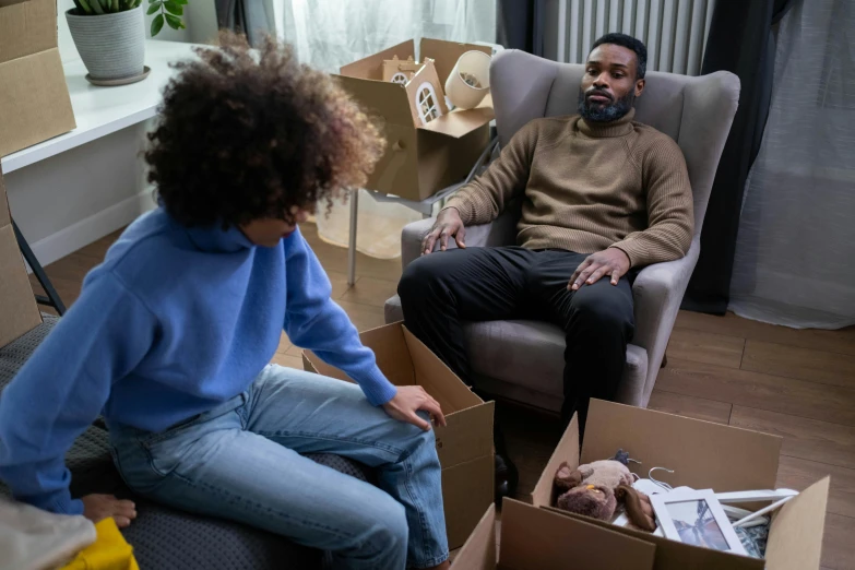 a man sitting in a chair next to a little girl, cardboard tunnels, teddy fresh, male and female, aftermath