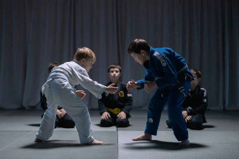 a couple of kids standing on top of a floor, sparring, dark blue and white robes, cinematography, grading