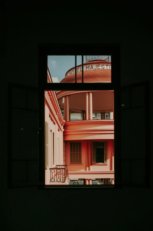 a view of a building through a window, inspired by Wes Anderson, unsplash contest winner, black and terracotta, museum light, neo-classical, view from inside