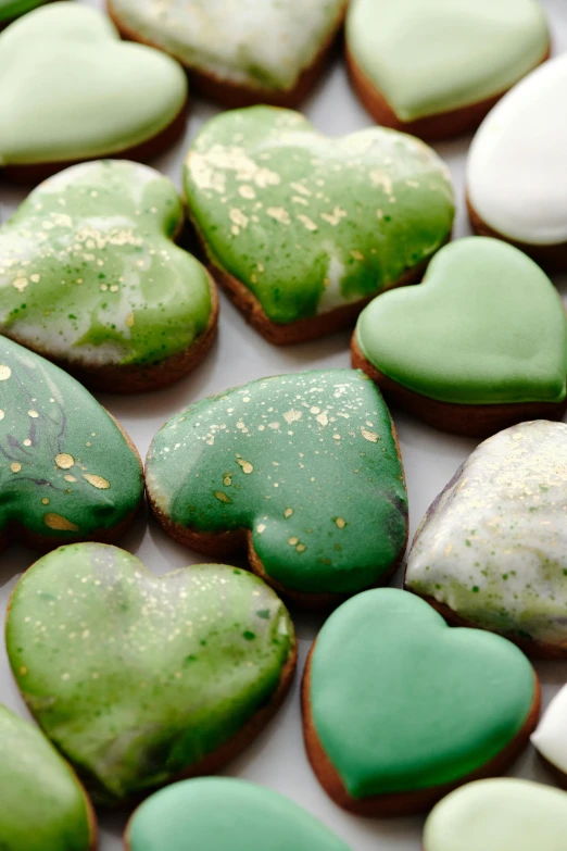 a bunch of green and white heart shaped cookies, inspired by Art Green, copper, highly polished, bio-inspired, close up details