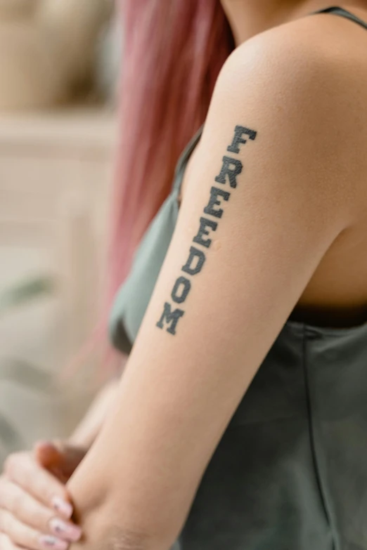 a woman with a tattoo on her arm, trending on pexels, freedom, trendy typography, patriotic, medium long shot