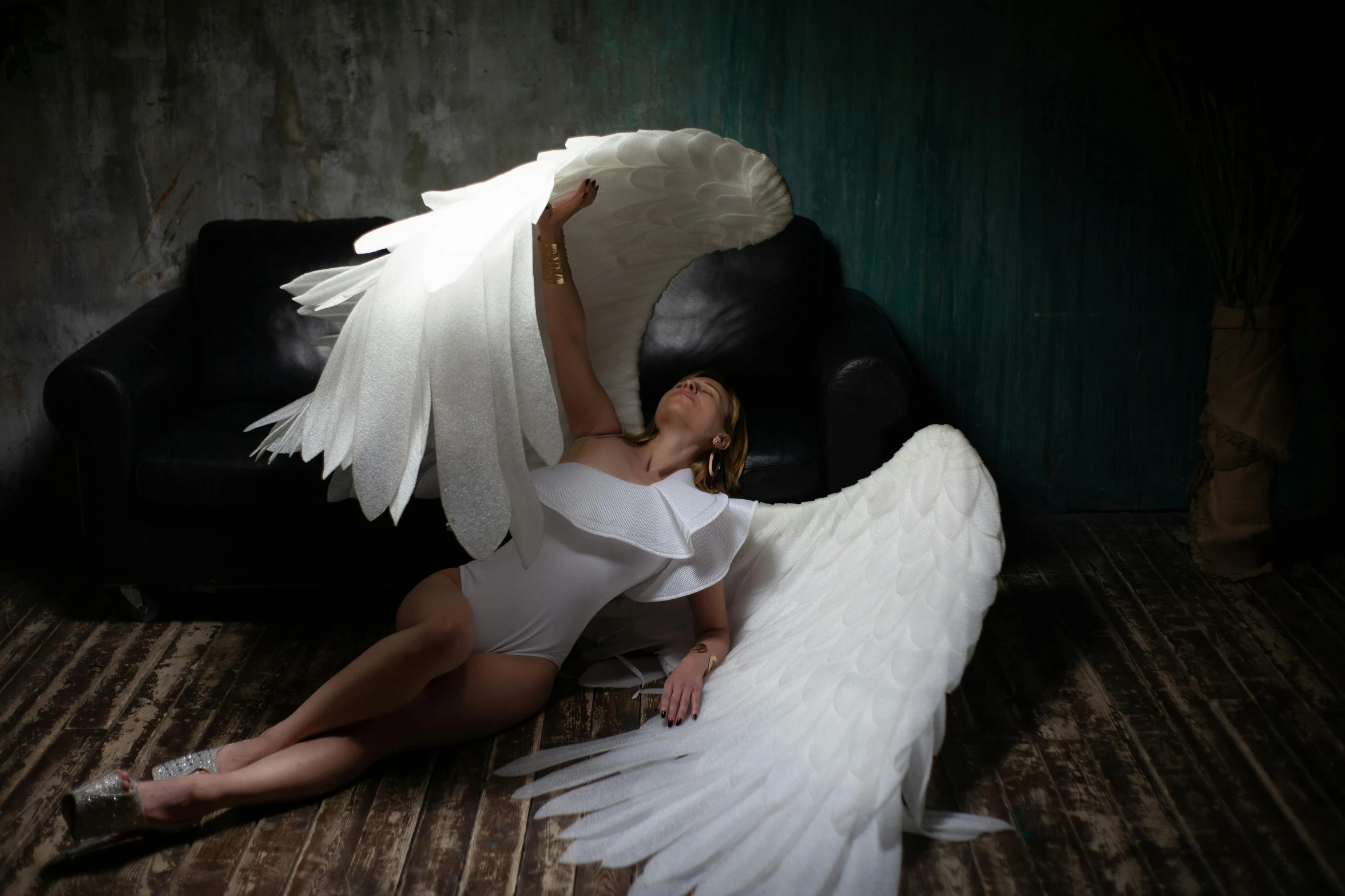 a woman in a white dress sitting on a wooden floor, inspired by Méret Oppenheim, pexels contest winner, fine art, with two pairs of wings, soft studio lighting, 165 cm tall, huge highly detailed wings