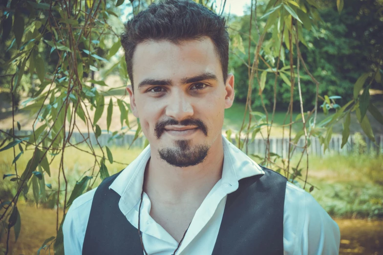 a man with a beard standing in front of a tree, a picture, inspired by Cristache Gheorghiu, pexels contest winner, renaissance, cute young man, halfbody headshot, headshot profile picture, short goatee