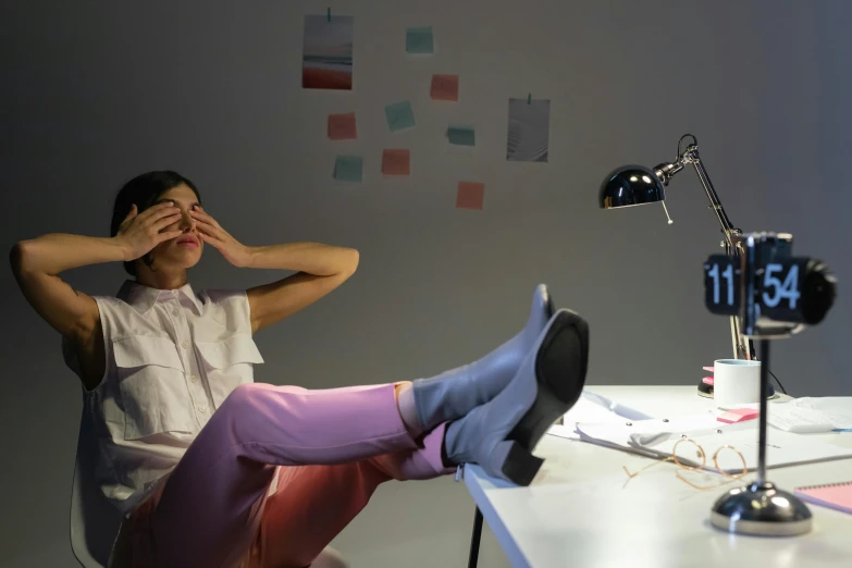 a woman sitting on a chair in front of a desk, inspired by Sarah Lucas, pexels contest winner, mood light, wearing nike air mags, sleepy feeling, parody work