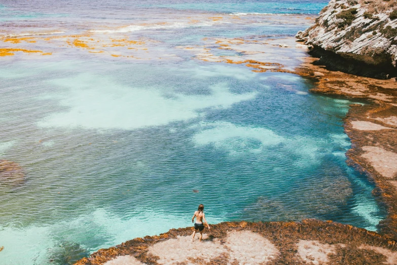 a man standing on top of a cliff next to the ocean, by Liza Donnelly, pexels contest winner, process art, turquoise rust, flatlay, aussie, 🤠 using a 🖥