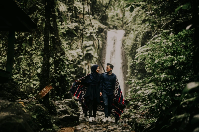 a man and a woman standing in front of a waterfall, pexels contest winner, hurufiyya, walking through a lush forest, hijab, avatar image, candid portrait photo