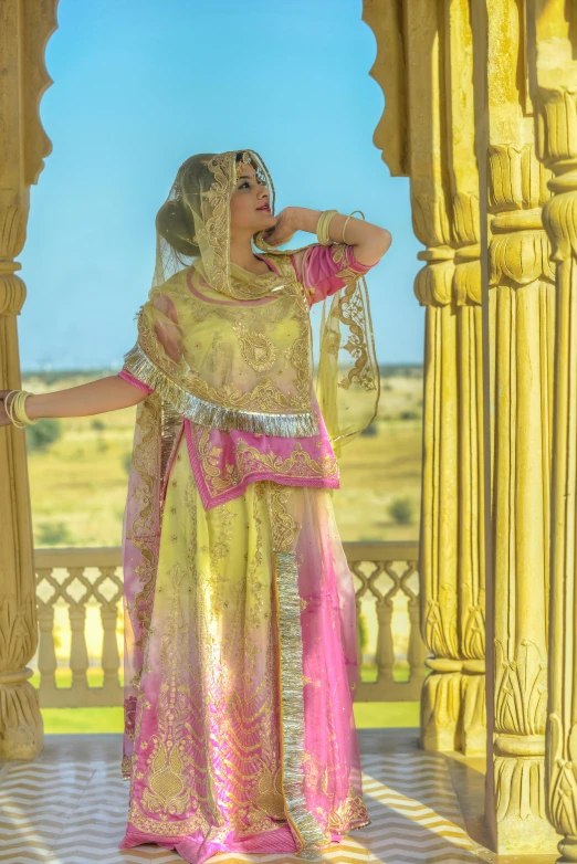 a woman in a yellow and pink outfit talking on a cell phone, inspired by Osman Hamdi Bey, renaissance, at khajuraho, movie promotional image, [ cinematic, bride