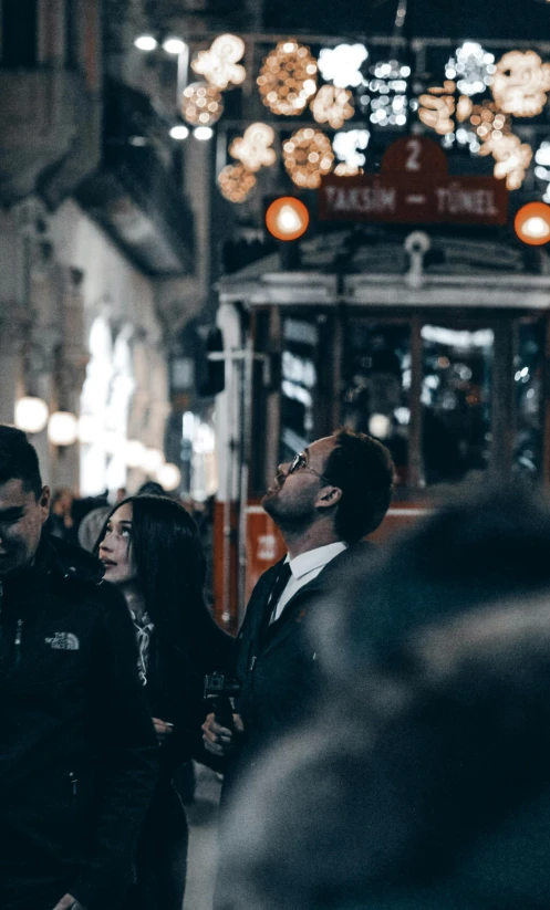 a group of people standing in front of a trolley, by irakli nadar, pexels contest winner, happening, istanbul, low quality photo, profile image, lights on