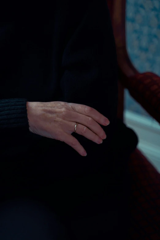 a woman sitting in a chair with a ring on her finger, unsplash, hyperrealism, still from the film, holding hands, swollen veins, close to night