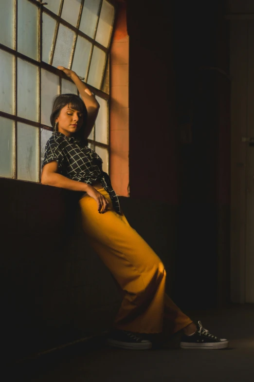 a woman leaning against a window in a dark room, by Dave Melvin, wearing yellow croptop, mai anh tran, in retro colors, fashion studio lighting