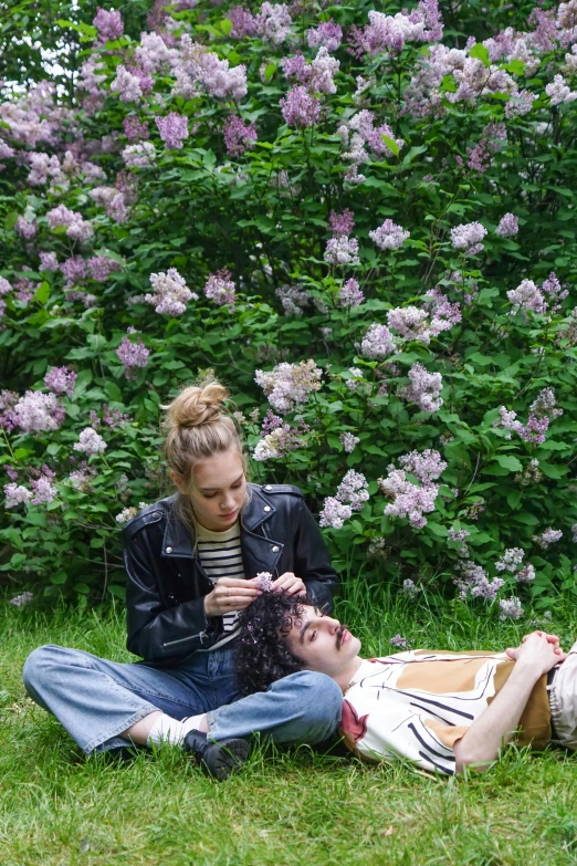 a couple of people that are sitting in the grass, trending on pexels, romanticism, lilacs, imogen poots, high angle shot, julia hetta