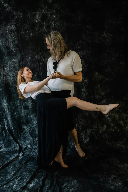 a couple of women standing next to each other, an album cover, inspired by Odd Nerdrum, unsplash, renaissance, man grabbing a womans waist, standing on two legs, gandalf as a woman, studio photo portrait