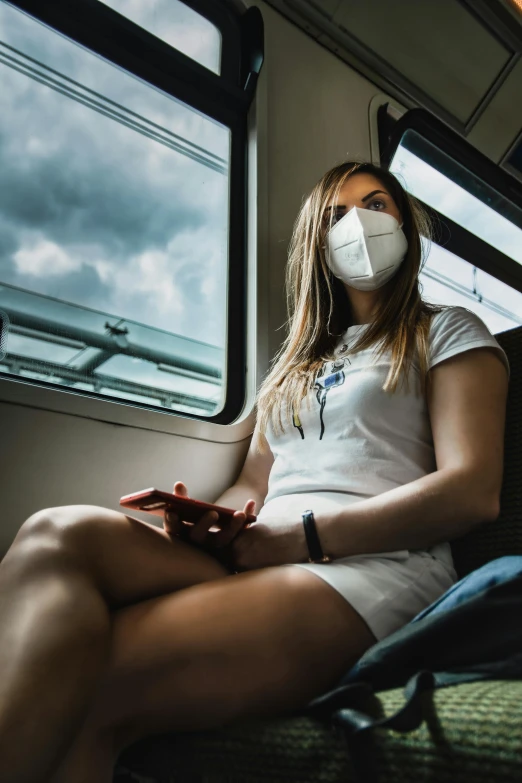 a woman wearing a face mask on a train, by Adam Marczyński, pexels contest winner, crossed legs, dust mask, integrated synthetic android, sitting in a fluffy cloud