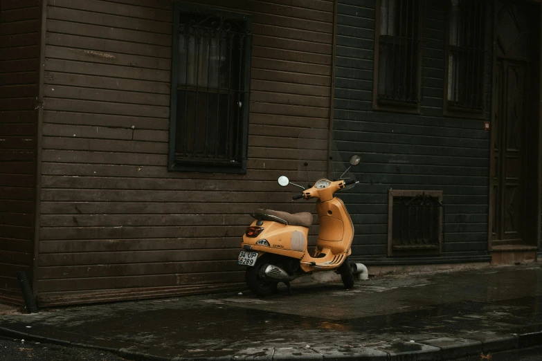 a motor scooter parked in front of a brown building, inspired by Elsa Bleda, unsplash contest winner, on a rainy day, mustard, high quality photo, octane renderer”