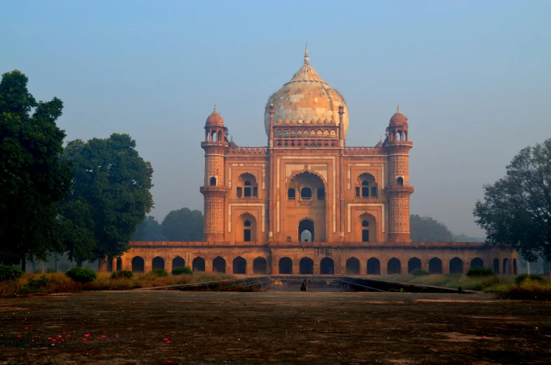 a large building sitting in the middle of a field, a marble sculpture, pexels contest winner, india, with great domes and arches, tomb, warmly lit