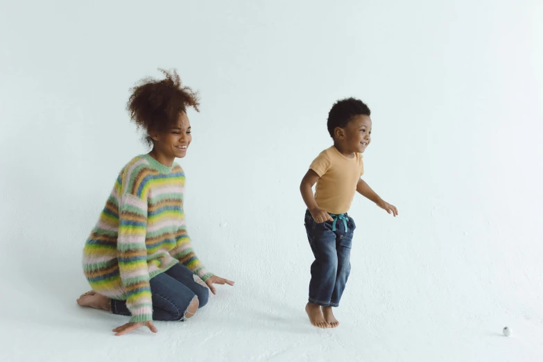 a woman and a child are sitting on the floor, bouncing, childish gambino, walking towards the camera, standing sideways