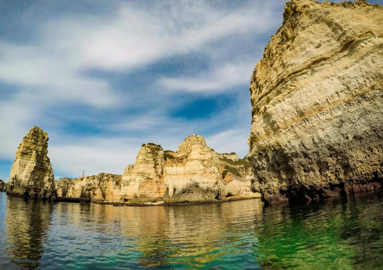 a body of water that has some rocks in it, by Simon Marmion, pexels contest winner, renaissance, sharp cliffs, apulia, photo taken from a boat, portugal