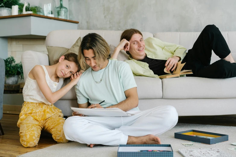 a couple of people that are sitting on the floor, a cartoon, pexels contest winner, caring fatherly wide forehead, drawing sketches on his notebook, conversation pit, portrait of family of three