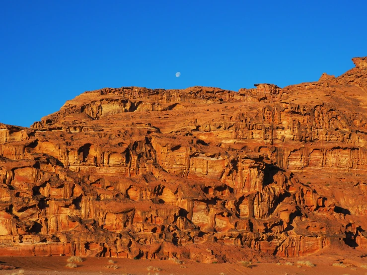 a large rock formation in the middle of a desert, pexels contest winner, hurufiyya, big moon on the right, jordan, high elevation, slide show