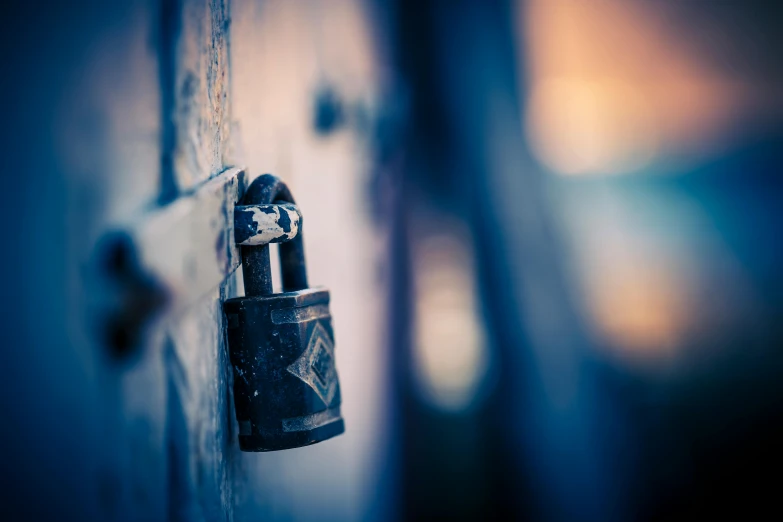 a close up of a lock on a door, a tilt shift photo, by Jesper Knudsen, unsplash, miscellaneous objects, background image, shades of blue and grey, lit in a dawn light