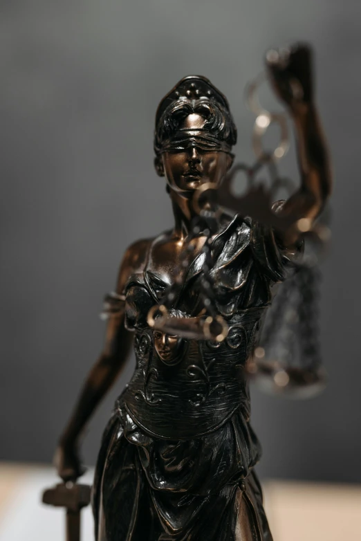 a statue of a lady justice holding a sword, a bronze sculpture, by Adam Marczyński, figuration libre, medium close - up ( mcu ), high angle shot, cinematic shot ar 9:16 -n 6 -g, small stature