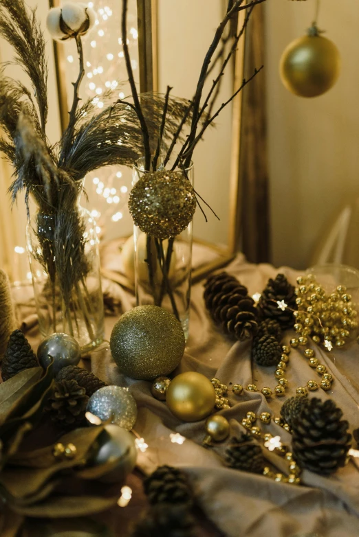 a table topped with vases filled with christmas decorations, a still life, pexels, baroque, shades of gold display naturally, detail shot, fairy lights, globes