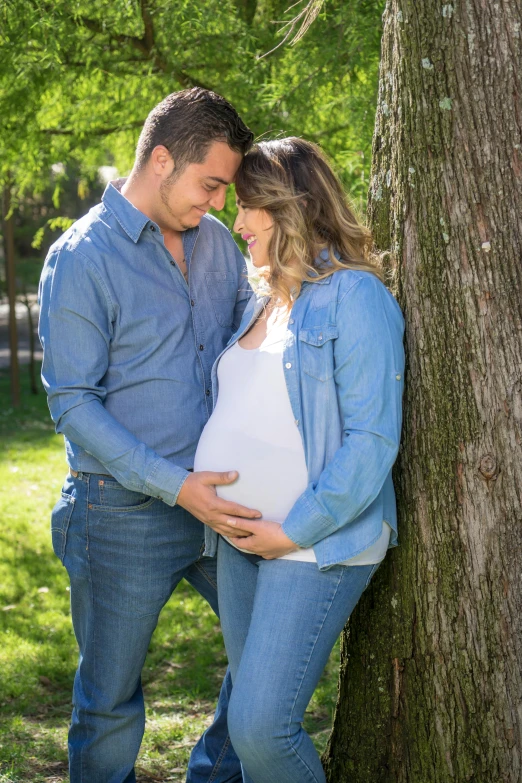 a pregnant couple leaning against a tree in a park, by david rubín, pexels contest winner, happening, denim, profile pic, giorgia meloni, happy family