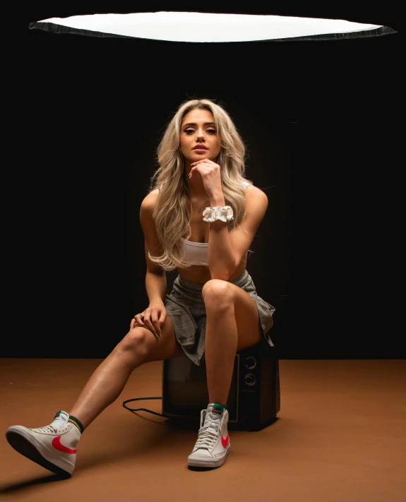 a woman sitting on top of a piece of luggage, inspired by Ion Andreescu, trending on pexels, wearing nike air mags, tifa lockhart with white hair, bodybuilding woman, xqc