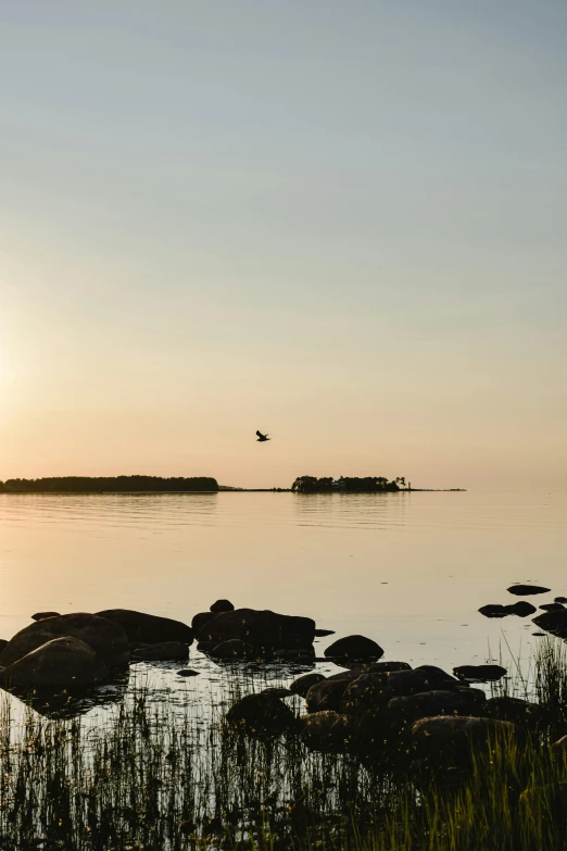 the sun is setting over a body of water, by Jan Tengnagel, flying rocky island, oland, in a quiet moment, high-quality photo