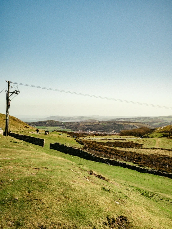 a telephone pole sitting on top of a lush green hillside, by Julian Hatton, pexels contest winner, happening, holywood scene, panorama distant view, faded worn, slide show