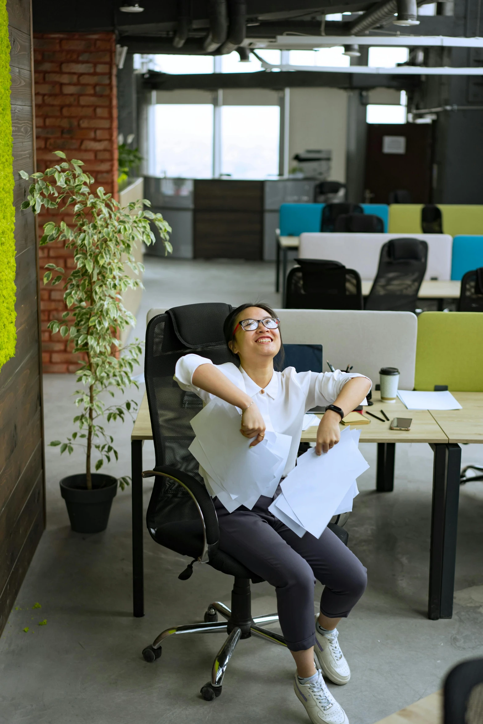 a woman sitting in a chair in an office, by Jang Seung-eop, pexels contest winner, mutahar laughing, lush environment, ergonomic, high angle