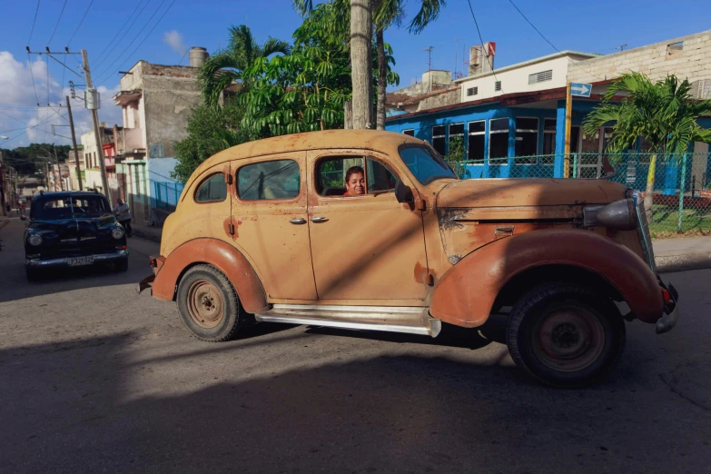 an old car is parked on the side of the road, el chavo, in style of joel meyerowitz, square, looking towards camera
