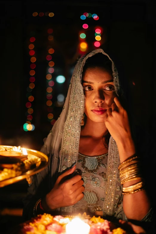 a woman sitting in front of a lit candle, intricate gold jewlery, arabian nights, 4 k film still, shot on nikon z9