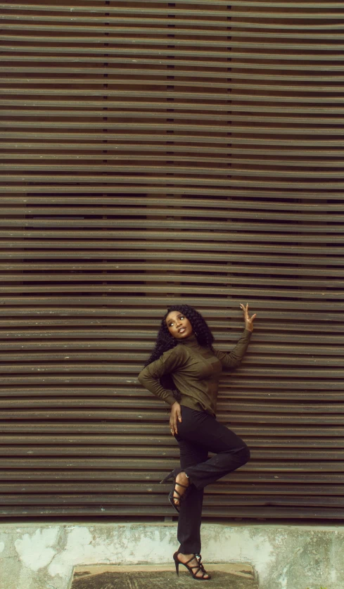 a woman standing in front of a garage door, an album cover, by Nyuju Stumpy Brown, pexels contest winner, serpentine pose gesture, sza, 15081959 21121991 01012000 4k, on a wall