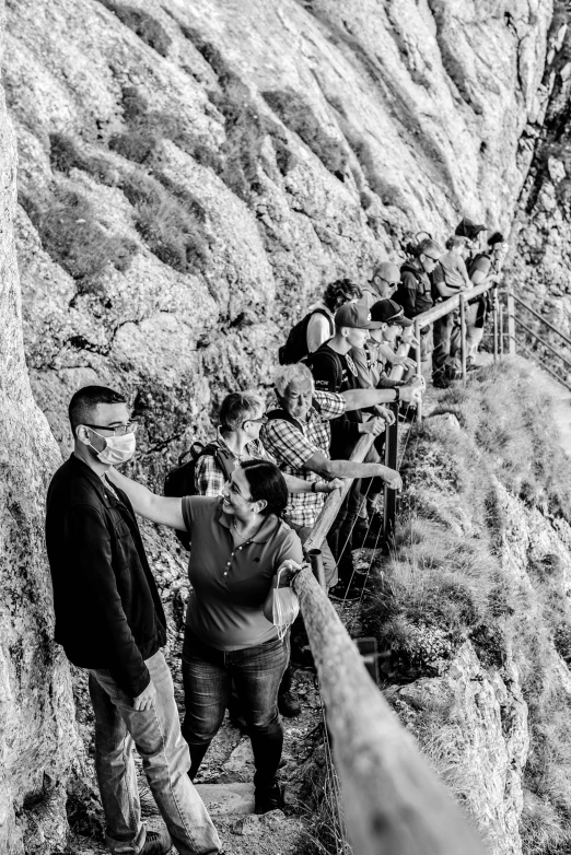 a group of people standing on top of a mountain, a black and white photo, happening, fence line, calanque, taken in 2 0 2 0, on a bridge