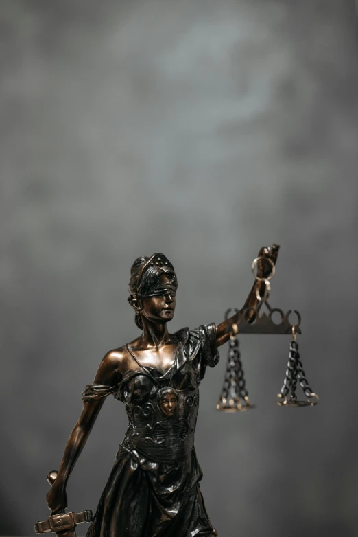 a statue of lady justice holding a sword, a statue, trending on pexels, on a gray background, blurred, balancing the equation, high angle