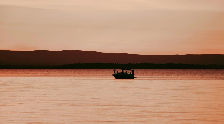 a boat in the middle of a large body of water, by Emma Andijewska, pexels contest winner, romanticism, orange / pink sky, slightly tanned, inuit heritage, afternoon hangout