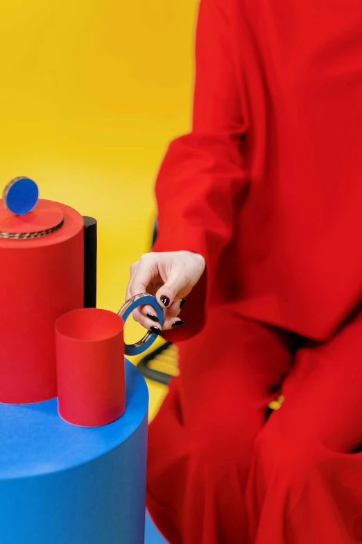 a person in a red shirt holding a pair of scissors, inspired by Tom Wesselmann, trending on unsplash, kinetic art, art toys on a pedestal, red and blue garments, cups and balls, detail shot